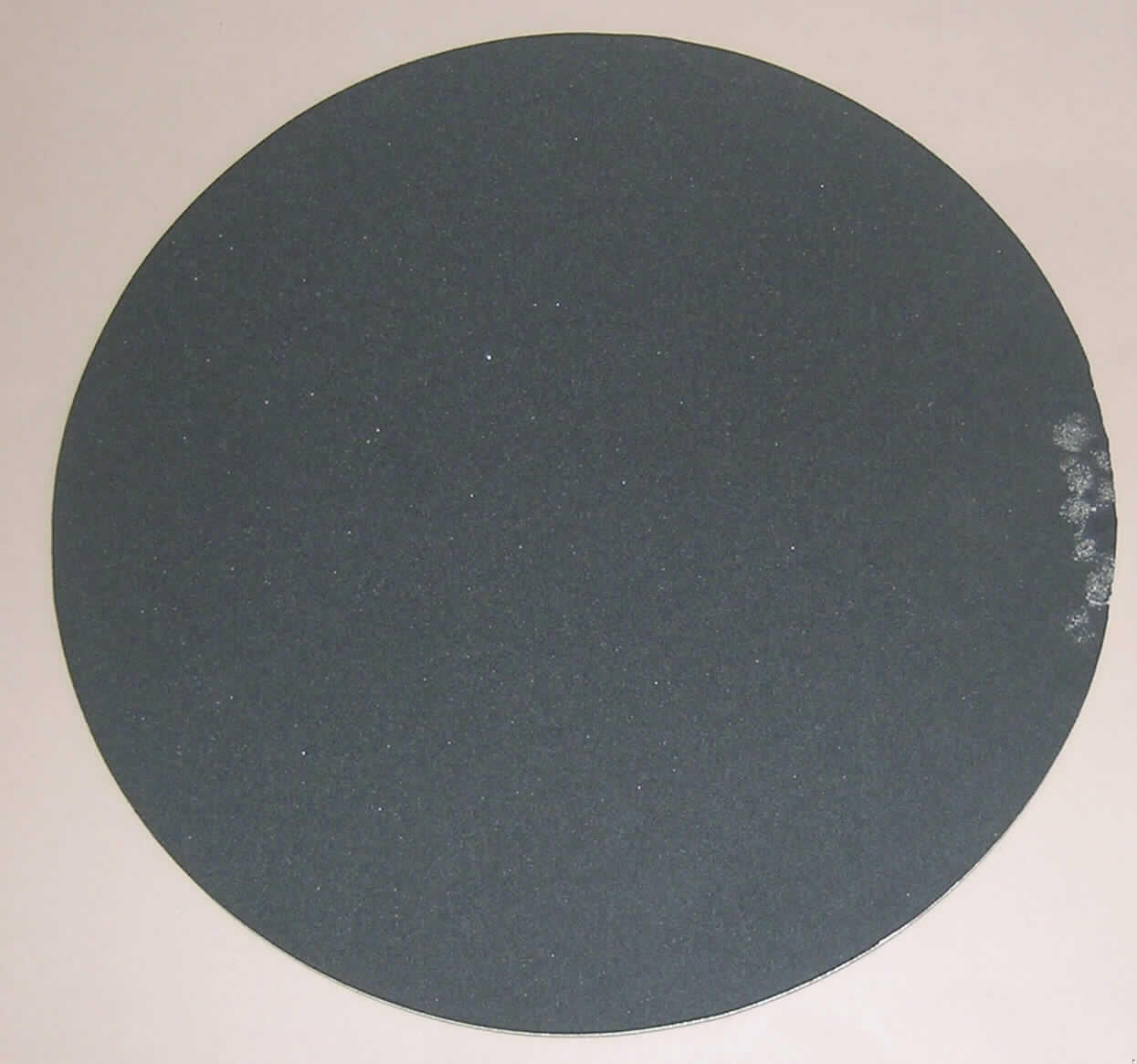 Mousepad

Rundes Mousepad mit einem farbigen Aufdruck (Werbeaufdruck).
Die Unterlage bildet eine dicke zellige Kautschuklage. Die obere Schicht besteht aus einer Papierlage und einer Kunststofffolie.

Analytische Daten:
IR-Spektrum (von der schwarzen Unterlage): wie ein Kautschuk
                   (von der oberen Folie): wie Polyvinylchlorid
Lupenbild     (schwarze Unterlage): Zellkautschuk
Burchfield-Test (schwarze Unterlage): positiv auf Kautschuk
Lagenaufbau: Unterlage ca. 3,5 mm Zellkautschuk
                    Papier und Folie gesamt ca. 0,33 mm
Nach den Untersuchungen besteht die dickste Lage der Ware aus Zellkautschuk und ist somit charakterverleihend.