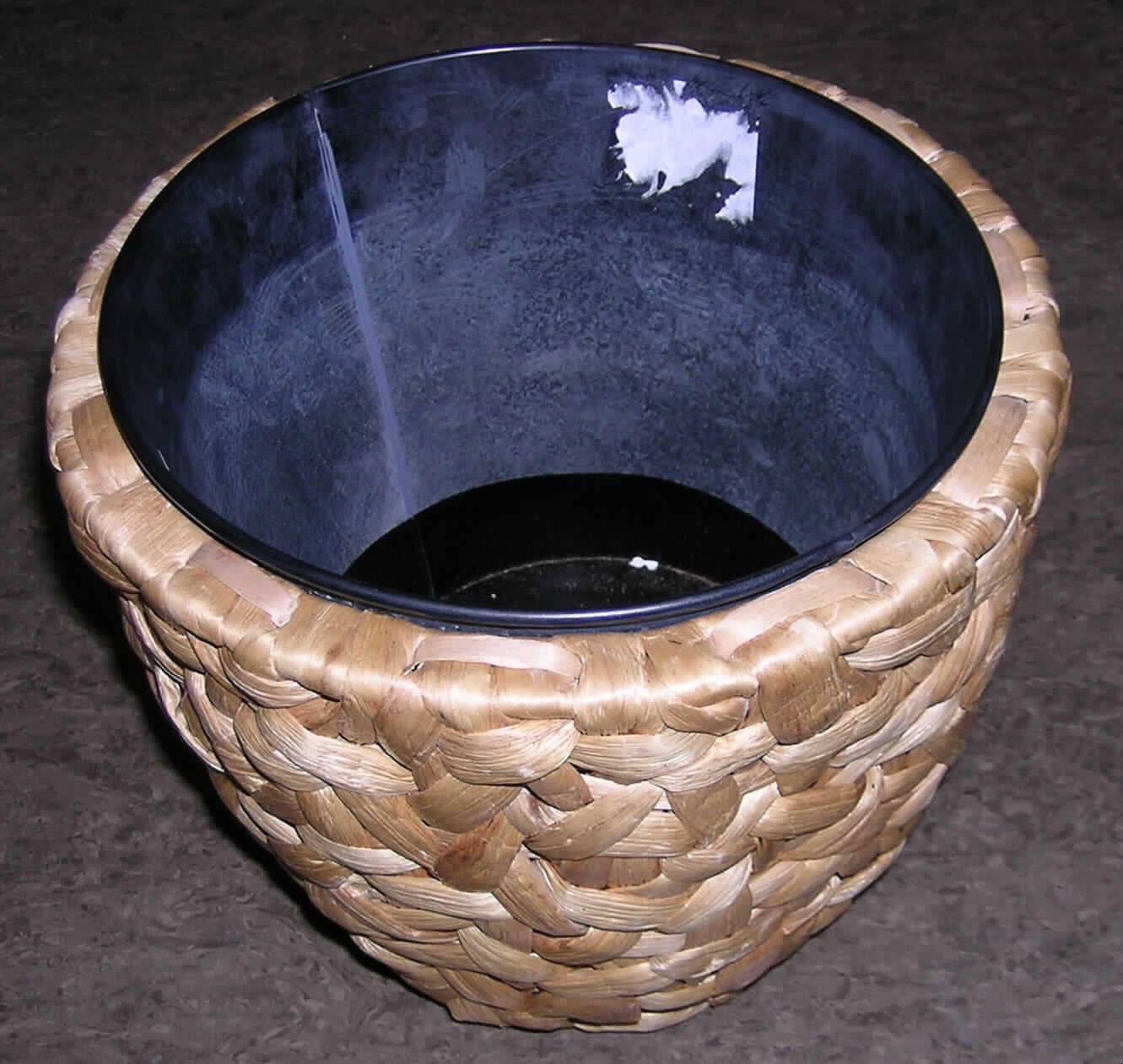 Flechtstoffware in Form eines dekorativen Übertopfes für Pflanzen
- in Becherform gearbeitet
  (Höhe ca. 25 cm, oberer Durchmesser ca. 27 cm, unter Durchmesser ca. 19 cm),
- unmittelbar aus pflanzlichen Flechtstoffen hergestellt (aus lt. Angaben des Antragstellers 
  Streifen von Wasserhyazinthe, die um ein Drahtgestell aus unedlem Metall geflochten sind),
- mit einem herausnehmbaren, eimerartigen Einsatz aus unedlem Metall, 
Insbesondere im Hinblick auf die Zierwirkung verleihen die Flechtstoffe der Ware ihren Charakter.