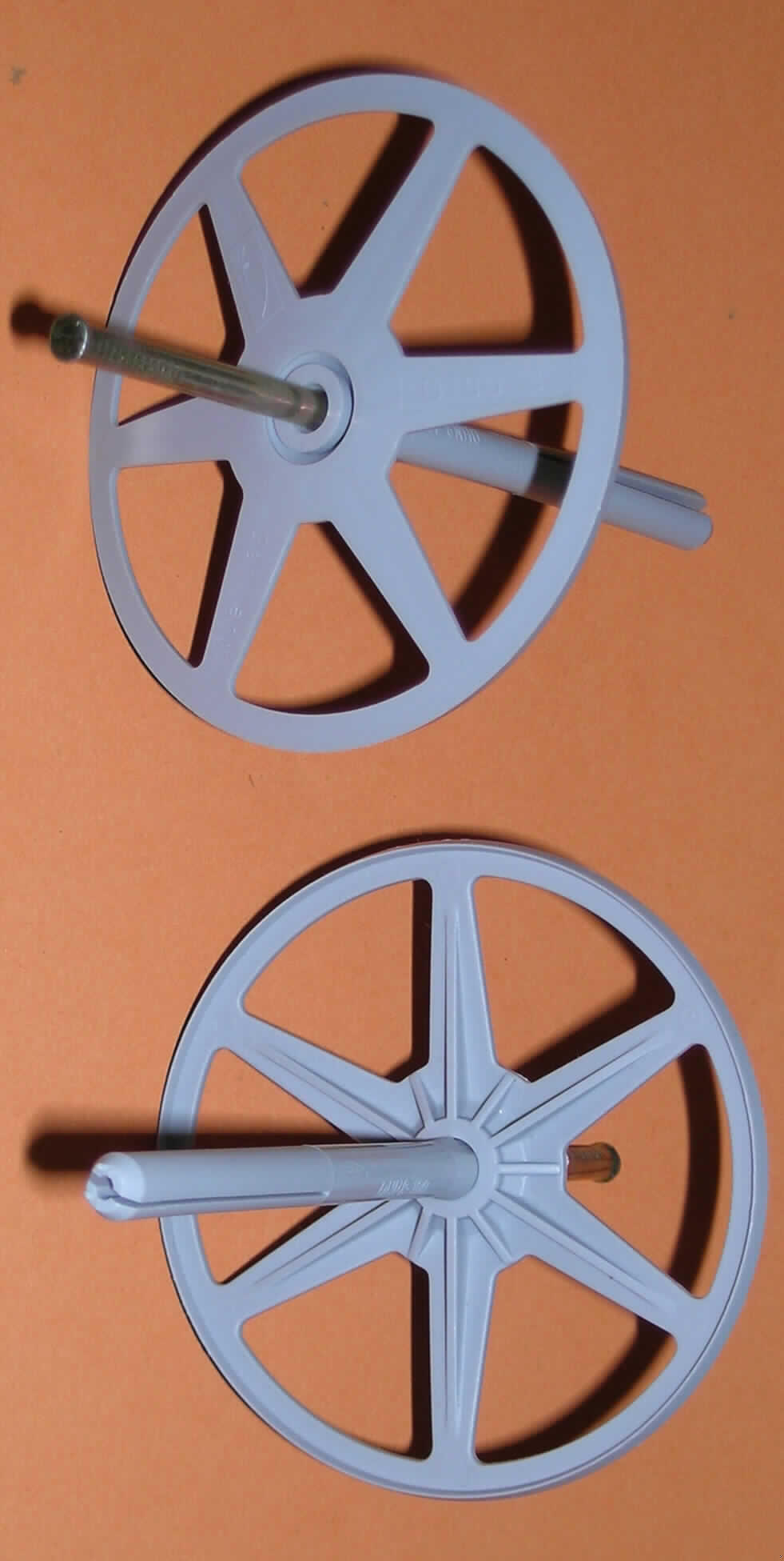 Dämmstoffhalter DHN
Es handelt sich um eine zusammengesetzte Ware zur Befestigung von weichen Dämmstoffplatten (z. B. aus Glaswolle) an Gebäudewänden mittels Durchsteckmontage. Der Dämmstoffhalter ist aus einem Kunststoff im Sinne der Anmerkung 1 zu Kapitel 39 gefertigt und besteht aus einem Dübel (Länge ca. 90 mm) mit einer ca. 50 mm langen Spreizzone sowie einem aufgesetzten "Teller" (Durchmesser ca. 90 mm) mit sechs flexiblen, speichenähnlichen angeordneten Rippen zum Anpressen der Dämmplatten. Er ist mit einem vormontierten Nagel aus Stahl ausgestattet. Charakterverleihend nach Umfang, Wert und Verwendungszweck ist der Kunststoff.