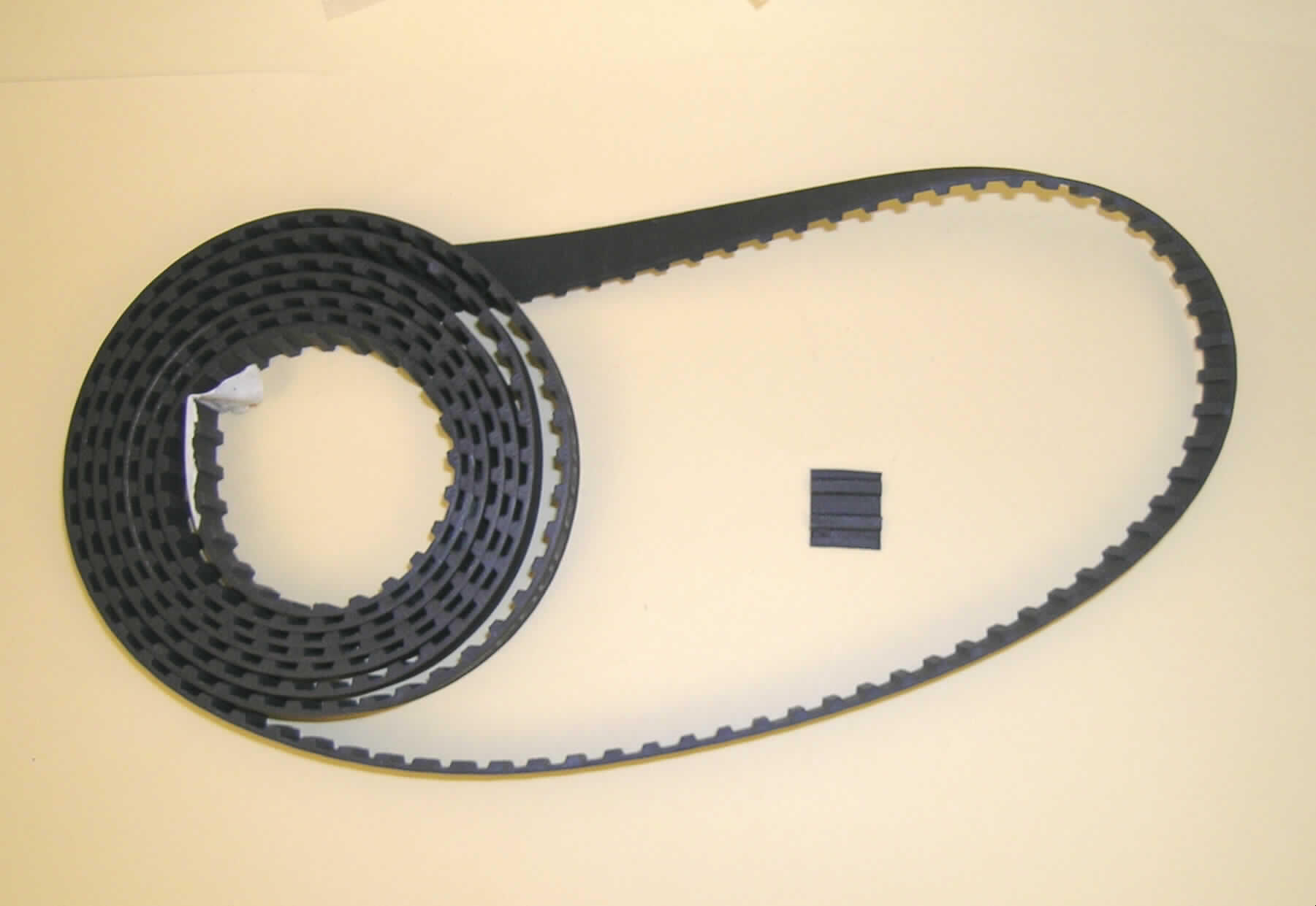 Synchrontreibriemen (Zahnriemen) aus vulkanisiertem Kautschuk

Ein vorgelegtes Warenmuster hatte folgende Eigenschaften:
Abschnitt eines schwarzen Synchrontreibriemens mit einer Breite von ca. 19 mm. Der vorliegende Abschnitt hat eine Länge von mehr als 240 cm. Der Treibriemen zeigt auf der Innenseite ein Zahnprofil.

Analytische Ergebnisse:
IR-Spektrum: schwarze Kautschukmasse im Wesentlichen wie Kautschuk
Schwefelnachweis: positiv                      
Burchfieldtest: Hinweis auf Kautschuk
Lupenbild: Kautschuk verstärkt mit Spinnstoffeinlagerungen

Nach den Untersuchungen liegt ein Zahnriemen aus Kautschuk vor, der verstärkt wird durch Spinnstofffasern.