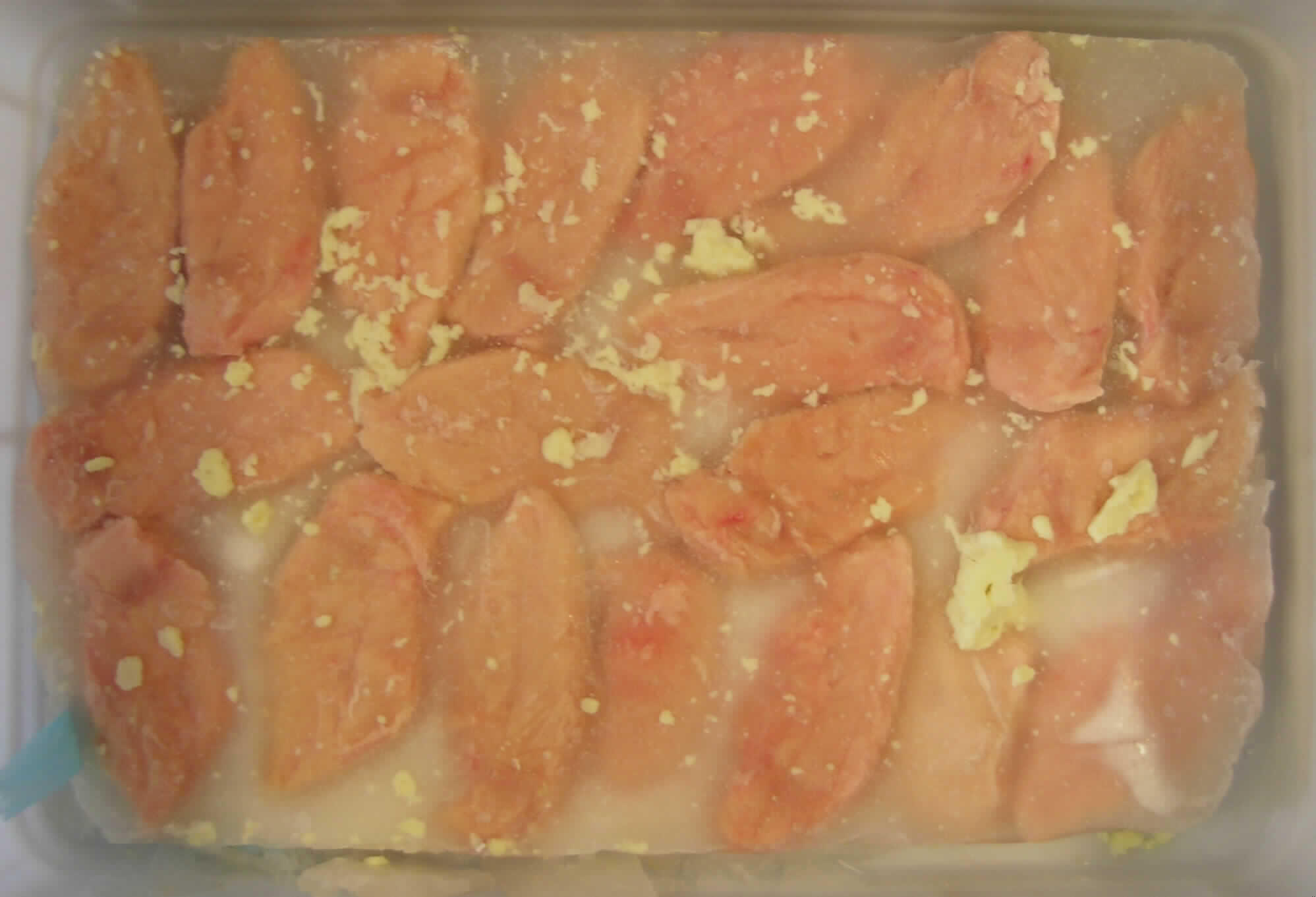 Warenbeschreibung des Antragstellers:
Fleisch von Hühnern, anders zubereitet, gefroren, Hähnchenbrustfilet ohne Haut und Knochen mit einem Anteil an Fleisch von 50 GHT. Eingelegt in einer Hähnchen eigenen Fleischbrühe (bestehend aus Wasser, Hähnchen-Fett, Salz und Pfeffer) in Polybeutel verschweißt.

Untersuchungsergebnis einer Warenprobe:
Vorgelegte Aufmachung: gefrorener Block in Kunststofffolie gewickelt
Eigengewicht (g): 5909 g
Warenbeschreibung: In Eis eingebettete rohe Hähnchenbrusthälften ohne Haut und ohne Knochen, im Block gefroren, mit einigen Fettklumpen im und auf dem Block. Nach dem Auftauen lagen die Hähnchenbrusthälften in einer wässrigen, stark salzig und brühig schmeckenden Flüssigkeit vor. 
Fleischanteil (Präparative Trennung): ca. 55 %.

Nach diesem Untersuchungsergebnis handelt es sich um rohes, zubereitetes Hühnerfleisch mit einem Fleischanteil von mehr als 25 % jedoch weniger als 57 %.