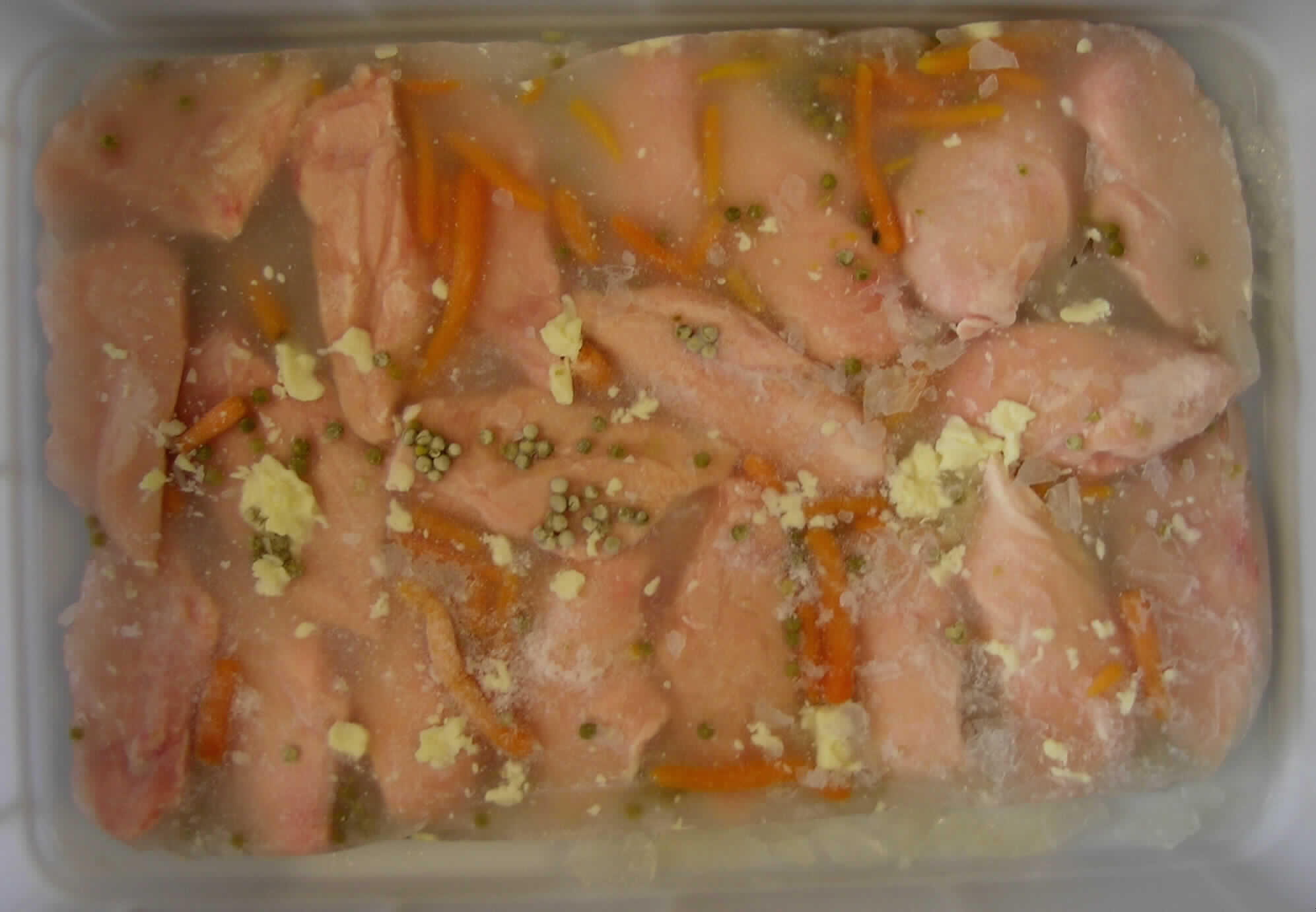 Warenbeschreibung des Antragstellers:
Fleisch von Hühnern, anders zubereitet, gefroren, Hähnchenbrustfilet ohne Haut und Knochen mit einem Anteil an Fleisch von 50 GHT. Eingelegt in einer Hähnchen eigenen Fleischbrühe (bestehend aus Wasser, Gemüse, Hähnchen-Fett, Salz und Pfeffer) in Polybeutel verschweißt.

Untersuchungsergebnis einer Warenprobe:
Vorgelegte Aufmachung: gefrorener Block in Kunststofffolie gewickelt
Eigengewicht (g): 5968 g
Warenbeschreibung: In Eis eingebettete rohe Hähnchenbrusthälften ohne Haut und ohne Knochen, im Block gefroren, von gegarten Erbsen und Möhren durchsetzt und mit einigen Fettklumpen im und auf dem Block. Nach dem Auftauen lagen die Hähnchenbrusthälften in einer wässrigen, von Gemüse (Erbsen und Möhren) durchzogenen,  stark salzig und brühig schmeckenden Flüssigkeit vor. 
Fleischanteil (Präparative Trennung): ca. 54 %, Gemüseanteil: ca. 6 %

Nach diesem Untersuchungsergebnis handelt es sich um rohes, zubereitetes Hühnerfleisch mit einem Fleischanteil von mehr als 25 % jedoch weniger als 57 %.