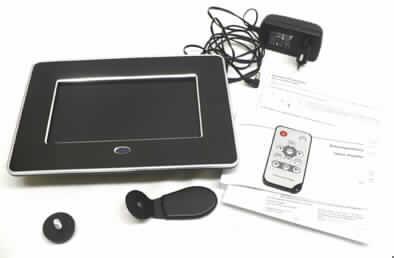 Digitaler Bilderrahmen
- aus einer 7 Zoll Farb-TFT-Flüssigkristallanzeige (Bildschirmdiagonale 17,78 cm, 
  Bildschirmformat 16:9), Hintergrundbeleuchtung und Signalelektronik in einem Gehäuse 
  mit separat beigelegtem Standfuß (Abmessungen 225 x 160 x 32 mm), mit Speicher- 
  kartensteckplatz (SD/SDHC/MMC/MS-Karten), Bedienelementen, IR-Empfänger, USB- 
  und 12 V Eingangsgleichstromanschluss (Abbildung siehe Anlage),
- zur Anzeige von Bildern (kennzeichnende Haupttätigkeit), zum Aufzeichnen und 
  Wiedergeben von Bilddateien im JPEG-Format sowie zur Verwendung als Uhr mit 
  Datumsanzeige und Kalender,
- zusammen mit Beipack (Netzteil, Fernbedienung, Bedienungsanleitung) in einer 
  gemeinsamen Verkaufsverpackung.
Der Digitale Bilderrahmen bestimmt den Charakter des Ganzen.
  
"Monitor, ohne eingebautes Fernsehempfangsgerät, mit Flüssigkristallanzeige, nicht von der 
 ausschließlich oder hauptsächlich in einem automatischen Datenverarbeitungssystem der 
 Position 8471 verwendeten Art, für mehrfarbiges Bild, nicht zum Einbau in Waren der Kapitel 
 84 bis 90 und 94 geeignet und mit einem Bildschirmformat von 16:9 - Kombination aus 
 Monitor (kennzeichnende Haupttätigkeit) und Bildaufzeichnungs- und -wiedergabegerät, 
 zusammengesetzt mit nicht charakterbestimmender Uhr, noch nicht zusammengesetzt mit 
 Standfuß, in Warenzusammenstellung mit nicht charakterbestimmendem Beipack."