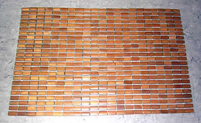 Holzmatte,
- aus flächig nebeneinander gelegten massiven Bambusplättchen (L x B x Dicke: 40 x 20 x 5 mm),
  auf eine Kunststoffschnur aufgefädelt, mit einem schmalen, weichen und stoßdämpfenden
  Kunststoffband in den querlaufenden Zwischenräumen,
- rechteckig (ca. 89 x 60 cm), 
- zur Verwendung als Fußmatte.
Das Holz (Bambus) bestimmt im Hinblick auf die Verwendung den Charakter der Ware
(Abbildung siehe Anlage).

"Andere als in den Positionen 4401 bis 4420 und den Unterpos. 4421 1000 00 0 bis 4421 9098 10 0 erfaßte Ware aus Holz (zusammengesetzte Ware aus Bambus -charakterbestimmend- und Kunststoff); sog. Holzmatte"