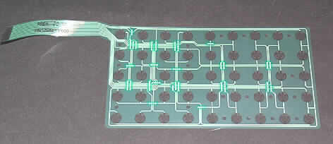 Folienschaltung (Abbildung siehe Anlage),
- in Form einer einlagigen gedruckten Schaltung aus einer flexiblen Kunstofffolie mit
  Folienleiteranschluss, mit in einem Druckverfahren hergestellten Leiterbahnen aus Silber 
  und Kontaktflächen aus Karbon versehen,
- zum Einbau in eine Tastatur für Kassensysteme bestimmt.

"Gedruckte Schaltung, nur mit Leiterbahnen oder Kontakten, keine Mehrlagenschaltung"