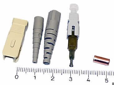 Bausatz für optischen Verbinder (Abbildung siehe Anlage),
- aus einer Keramik-Ferrule in einem sepzifisch geformten Kunststoffinnengehäuse,
  einem Außengehäuse aus Kunststoff zur Aufnahme der Ferrule, einer Crimphülse,
  zwei verschiedene Kabelknickschützer und einer Schutzkappe,
- noch nicht zusammengesetzt,
- zum Verbinden und mechanischen Ausrichten von optischen Fasern, Bündeln aus
  optischen Fasern oder optischen Kabeln.

"Verbinder für optische Fasern, Bündel aus optischen Fasern oder optische Kabel;
 noch nicht zusammengesetzt - Bausatz für optischen Verbinder"