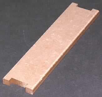 Isolierteil (Zwischenstück),
- formgestanztes Teil mit ausgestanzten Einkerbungen an beiden Schmalseiten, ganz aus 
  ungebleichtem Nadelholzzellstoff, mit den Abmessungen 12,3 x 3,0 x 0,6 cm 
  (Abbildung siehe Anlage),
- zur elektrischen Isolation von Transformatoren.

"Isolierteile, ganz aus Isolierstoffen (Nadelholzzellstoff) für elektrische Maschinen, Apparate, 
 Geräte oder Installationen"