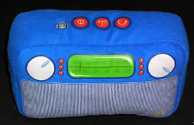 Batteriebetriebenes Radio 
- aus FM-Empfänger für den Rundfunk mit Verstärker, Lautsprecher, Bedienelementen und 
  Batteriefach in einem Kunststoffgehäuse (Abmessungen ca. 95 x 60 x 28 mm), eingepasst 
  und befestigt in einen bunten, gepolsterten Überzug aus textilen Spinnstoffen 
  (Abmessungen: ca. 160 x 110 x 60 mm, Abbildung siehe Anlage),
- zum Empfang von Rundfunksendungen.
Das Rundfunkempfangsgerät bestimmt den Charakter des Ganzen.

"Rundfunkempfangsgerät, das ohne externe Energiequelle betrieben werden kann, 
kein Radiokassettengerät, nicht kombiniert mit Tonaufnahme- oder Tonwiedergabegerät, 
zusammengesetzt mit nicht charakterbestimmendem Überzug"