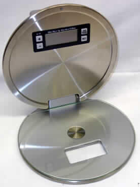 Wandwaage mit Zeitanzeige
- aus einem runden, scheibenförmigen, aufklappbaren Metallgehäuse (Durchmesser ca.
  22 cm) mit einer rechteckigen Aussparung in der oberen Hälfte des äußeren Gehäuseteils
  und einer mittels Magnet auf der Wiegeoberfläche befestigten Glasscheibe, sowie einem
  digitalen Anzeigefeld für Wiegeergebnis und Uhrzeit im inneren Gehäuseteil,
  Bedienelementen, eingebauter Uhr und zwei Batterien, mit einer Empfindlichkeit von 1 g
  (Abbildung siehe Anlage),
- zum Wiegen von Lebensmitteln etc. bis zu einem Gewicht von 3 kg und zum Anzeigen der
  Uhrzeit,
- in einer gemeinsamen Verkaufsverpackung mit Beipack (Wandhalterung, zwei Schrauben
  und zwei Dübel).
Die Waage bestimmt den Charakter des Ganzen.

"Haushaltswaage mit einer Empfindlichkeit von 1 g (zusammengesetzte Ware aus
 Haushaltswaage -charakterbestimmend- und Uhr in Warenzusammenstellung mit nicht
 charakterbestimmendem Beipack) - sog. Wandwaage mit Zeitanzeige"