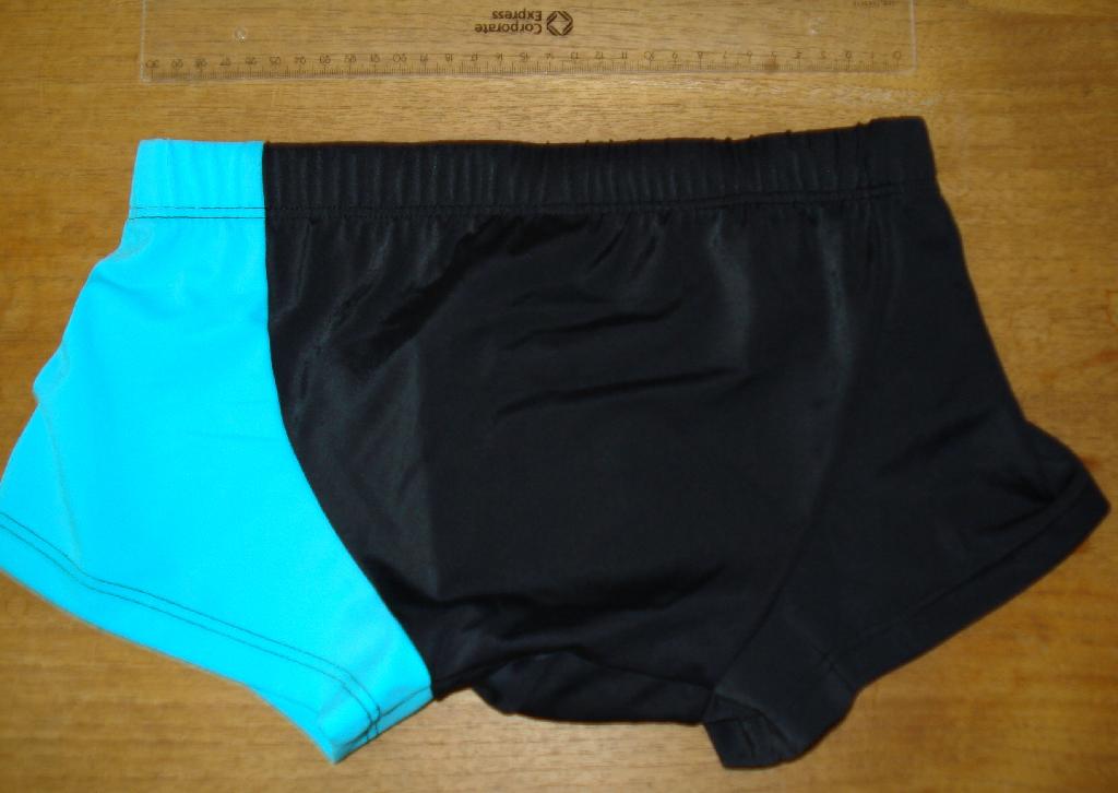 Varen fremstår som badebukser til en dreng.  

Varen er efter det oplyste fremstillet af en metervare med 83 % polyamid (nylon) og 17 % elasthan (spandex). Der er efter det oplyste ingen gummi i varen. 

Varen er strikket, er henholdsvis ensartet turkis (venstre side og bukseben) og sort (resten) og har følgende mål: ca. 19 cm i siden, ca. 62 cm i omkreds i taljen, ca. 22 cm i skridthøjde og tykkelse af stoffet under 1 mm. 

Varen har korte ben, der er kantet med ombuk, mens åbningen ved taljen er med løbegang med sort flettet bånd og elastik. Der er ikke andre åbninger i bukserne. Varen er foret med sort trikotagestof midt forpå.