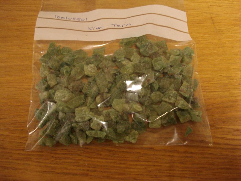 Produktet betegnes kiwitern og fremstår som tern i varierende størrelse (ca 1x1x1 cm eller derunder) i grønlige farver med nogle brune/sorte kerne med en svag hvid belægning på overfladen. Produktet smager sødt og svagt af kiwi. Varen er i bulk (over 1 kg).
 
Der er efter det oplyste ikke tilsat alkohol til produktet.