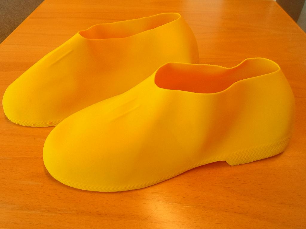 Skoovertræk - tages uden på de normale sko.

Produktet er støbt af naturgummi, og er uden syninger, søm og lignende.

Produktet er desuden vandtæt - og bruges indenfor glasfiberindustrien.

Kostpris 6 USD/PAR