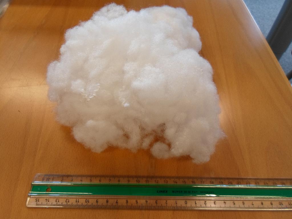 Fyld til sofapuder med en fiberlængde på ca. 5,0 til 6,5 cm. 
Varen foreligger som små, aflange, voluminøse, løse klumper af ujævn størrelse, de består af mange krøllede, hvide fibre, der foreligger uden foretrukken orientering.