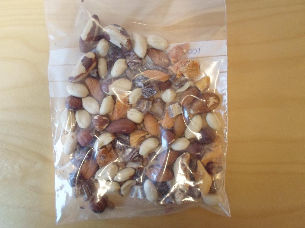 Produktet består ifølge den med anmodningen medsendte vareprøve af en blanding af: 
•	25,4 % usaltede peanuts,
•	18,0 % tørrede dadler (99 % dadler, 1 % rismel),
•	3,9 % honningristede solsikkekerner (87 % solsikkekerner, sukker, bomuldsfrøolie og/eller solsikkeolie, 1,5 % honning, salt, maltodextrin, stabilisator, xanthangummi),
•	20,8 % paranøddekerner,
•	12,8 % tørret mango (99,95 % mango, konserveringsmiddel; E220 (svovldioxid)),
•	9,1 % mandler,
•	10,0 % hasselnøddekerner. 

Varen foreligger i detailsalgspakning (1 kg og derunder).
