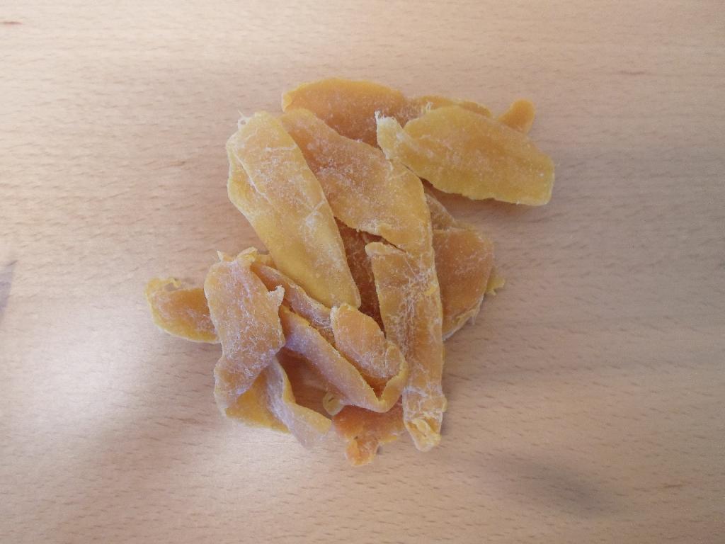 Produktet er tørret mango i stykker.

Produktet foreligger som aflange gulorange skiver med hvide krystaller på over-fladen. Stykkerne smager sødt af mango. 

Om fremstillingen er følgende oplyst: mango vaskes, skrælles, vaskes, skæres i skiver, tilføjes E220, tørres, tilføjes sukker, tørres og pakkes.