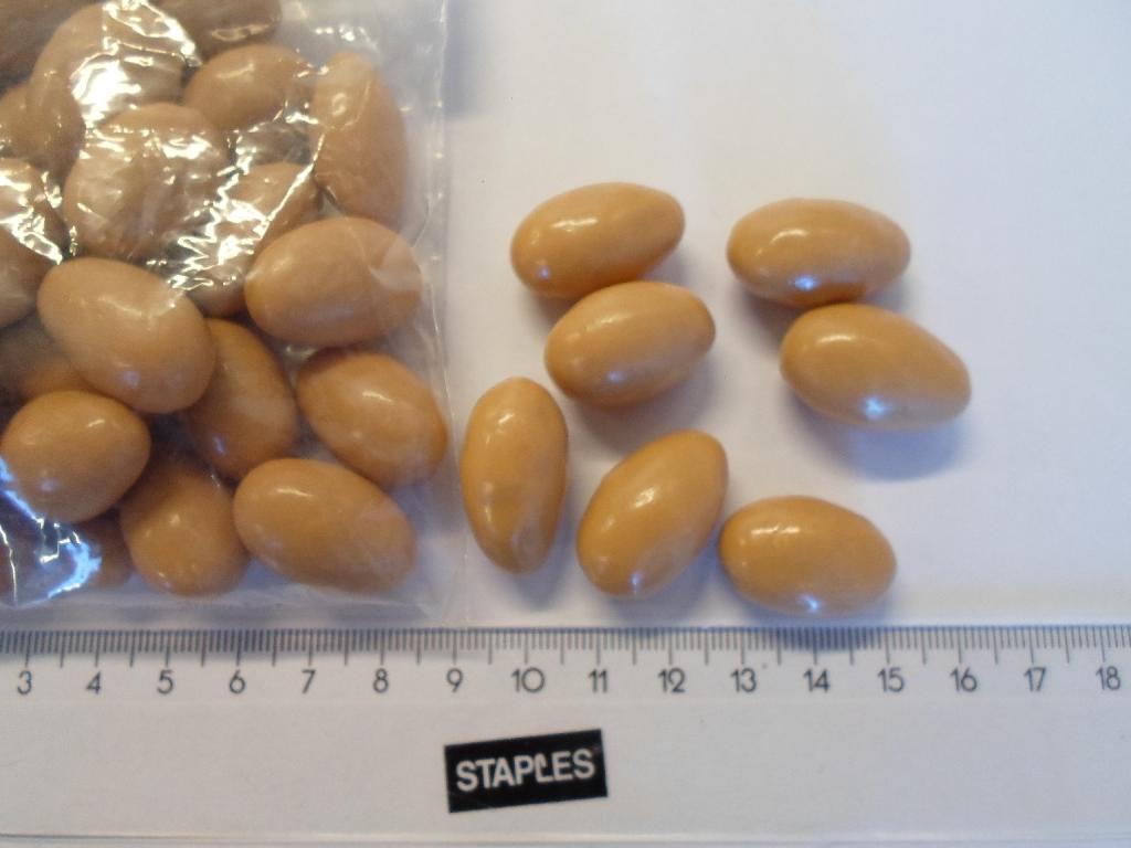 Varen foreligger som mandler belagt med lysebrun chokolade.
Varen er en fødevare.
Følgende indhold er oplyst:
-	XX % blanding af hvidchokolade og mælkechokolade med karamel smag (sukker, kakaosmør, mælkepulver, E322, karamelsmag, krydderier og natur-lig vanilje aroma)
-	XX % mandler
-	  XX % E414 (gummi arabikum) og E904 (shellak)
-	  XX % sukker
-	  XX % glukosesirup
-	  XX % salt

Mandlerne vendes (coates) i chokoladeblandingen således at mandlerne udgør XX % af varen. Varen køles herefter af.
Chokomandlerne er ca. 2,5 cm lange og formen er oval som mandler. Ved gennem-skæring ses en hel mandel med brun hinde, der er belagt med et lysebrunt lag (ca.4-6 mm). Smagen er en meget sød smag af mandler og karamel med et strejf af salt. 
Selve mandlen fremstår neutral. 

Varen frembydes både i pakninger på over og under 1 kg.