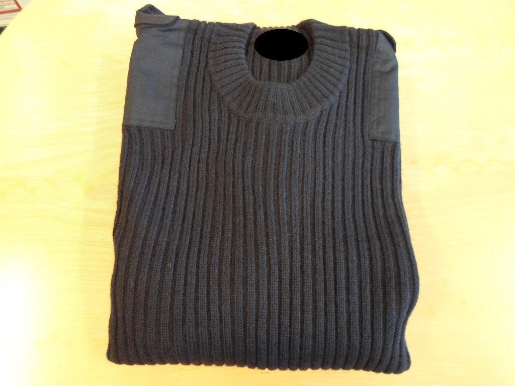 Varen foreligger som en mørkeblå pullover i armystil. Der er forstærkninger på skuldre og albuer, samt lommer på ærmerne. Endvidere er der velcrolukninger på skuldrene.
Anvendes som beklædningsgenstand til overkroppen
Varen er lavet af trikotage, og efter producentens oplysninger består den af 80 % uld og 20 % akryl.
GSM (g. pr. kvadratmeter) er oplyst til at være 890 GSM. Varen er blevet vejet og den har en vægt på 876 g.