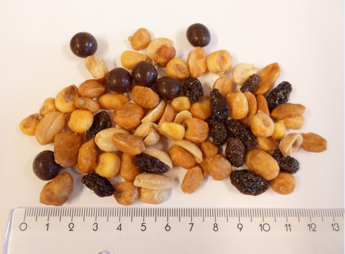 Varen består af:

- 20 % honningristede peanuts
- 20 % tørristede peanuts i saltlage
- 20 % ristede og saltede minimajs
- 20 % thompson rosiner
- 20 % mørke chokokugler

De honningristede jordnødder i varen, er ca. 1 cm lange. De fremstår uden skal og den brune hinde, og er enten halve eller hele. Farven er meget gylden og smagen er sød af honning og som jordnødder, der er ristede.

De tørristede jordnødder i saltlage er ca. 1,5 cm lange. De er uden skal og den brune hinde, og er enten halve eller hele. Farven er let gylden og smagen er let bitter som jordnødder, der er ristede og saltede. 


Minimajsene er op til ca. 1,5 cm lange. På majsene ses kimen tydeligt. Majsene er lys gylden i farven og meget sprøde. De smager af saltede majs. 

Rosinerne er ca. 1 cm lange. De er mørke i farven og smager sødt som rosiner. 

Chokoladekuglerne i varen er ca. 1 cm store. Farven er mørk. Smagen er som sød mørk chokolade.

Varen frembydes i detailsalgspakninger af nettovægt 1 kg og derunder.