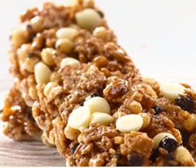 Varen er brun og har den ene side dækket af hvid chokolade. Der er hvide og mørke stykker chokolade i varen som er omgivet af ristede korn-flager og få ekspanderede ris. Varen er sat sammen med sirup. Varen smager sødt, er knasende og blød de ste-der hvor den hvide chokolader er.
Der er oplyst at varen er en morgenmads snack
Det er oplyst at varen indeholder, hvede, ris, glukose sirup, mælkepulver, malt eks-trakt, kakao stykker, stykker af hvid chokolade, oligofructose, glycerol, havre, dext-rose, hvede mel, palme olie, majsmel, sorbitol, sukker,salt, vitaminer, antioxidanter.
Er pakket i emballering til detail salg.