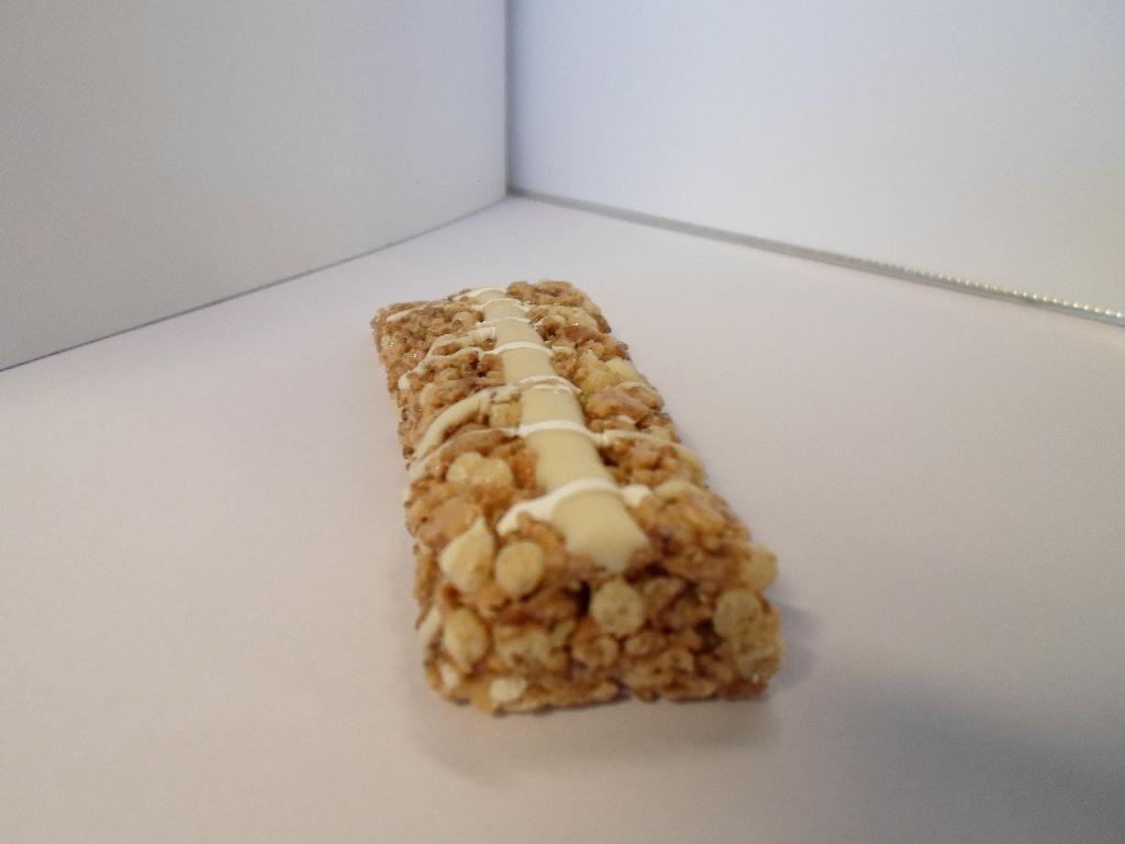 Varen er en bar lavet af korn arter med sukker og hvid chokolade tilsat. Chokoladen ligget som en stribe oven på baren, og der er fine tråde yoghurt over dette. Baren er knasende og smager sødt, med en eftersmag af kornene. Man kan fornemme smage af den hvide chokolade og yoghurten.
Varen er oplyst til at være en morgenmads snack eller en godbid.
Det er oplyst, at varen består af hvede, ris, glukose sirup, hvid chokolade, malt eks-trakt, sukker, sukker sirup, hvedemel, havre, glycerol, majsmel, calcium karbonat, palme olie, majs stivelse, salt, smagsstoffer, vitaminer og antioxidanter.
Varen er pakket i emballage til detailsalg.