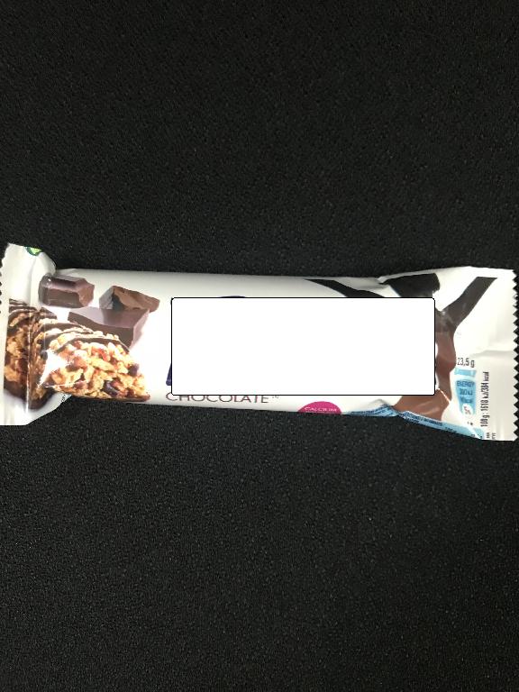 Varen er formet som en stang, med striber af chokolade på toppen. Bunden samt den nederste kant, er dækket af chokolade. Handelsbetegnelsen er Fitness Chocolate Cereal Bar (SKU: 12282435).
Varen er en fødevare og det er fra ansøger oplyst, at den kan anvendes som morgenmadssnack.
Det er oplyst, at varen har en vægt på 23,5 g, og at varen består af:
•korn (heraf hel fuldkornshvede, ris, fuldkornshavre, fuldkornshvedemel, majs semolina, rismel) 
•chokolade (heraf 35 % total kakao solids, inkl. min. 18 % kakaosmør og min. 14 % ikke fedt kakao solids) 
•kakaopulver
•fedt-reduceret kakaopulver
•Sukkersirup
•Mineraler
•Vitaminer

Varen er blevet analyseret, og resultatet viser, at varen skal indeholde 2,7 % kakao, jf. HPLC-metoden.
Varen er fremstillet ved at binde ristet korn og øvrige ingredienser sammen ved hjælp af sukkersirup. 

Stangen har en sød smag, samt en sprød og lidt klæbrig konsistens. 
Den er pakket ind i hvid plastfolie med et billede af varen påtrykt i venstre side, samt en chokoladefarvet figur i højre side. Varen er pakket i individuelle pakninger til detailsalg.