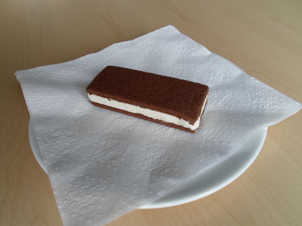 Varen kaldet ”Mælkesnitte med honning” foreligger som en mørkebrun bar, der består af to tynde lag kage med en hvid creme i midten. Varen er indpakket i en metalbelagt plastfolie med gul og hvid baggrund.

Baren måler ca. 8,8 x 3,5 x 1,8 cm.

Efter angivelsen er nettovægten 28 gram.

Varen er en mælkesnitte med honning, og kan betegnes som slik.

Ifølge medsendt dokumentation kaldet ”Product- and Logistic Data” og ingredienslisten på varens emballage indeholder varen følgende: 23 % sødmælk, 23 % vegetabilsk fedt (palmolie), 22 % sukker, 11 % hvedemel, 4 % glucose-fructose sirup, 4 % honning, 4 % sødmælkspulver, æggepulver, fedtfattig kakao, kartoffelstivelse, mælkeprotein, aromastoffer, emulgatorer, bagepulver, salt, vand. 

Desuden er der angivet, at varen består af 38% bagværk og 62 % creme.

Varen indeholder ifølge medsendt dokumentation følgende: 27 % fedt, 44 % kulydrater, heraf 33 % sukker og 5 % protein.

Ifølge angivelsen indeholder kagepladerne kakao.

Varen er blød og kagepladerne er luftigt som kage plejer at se ud. Den smager sødt og frisk af mælk og vanilje. Varen dufter af honning.