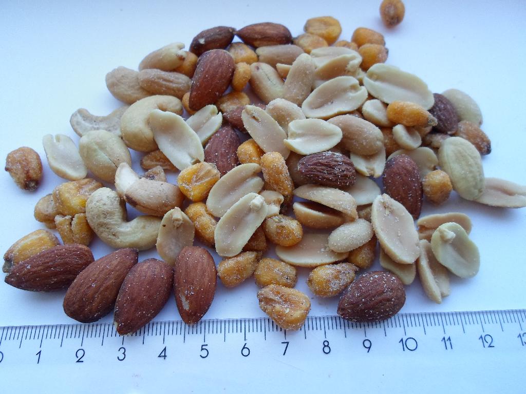 Varen er en blanding af nødder og minimajs.
Varen kan indtages som føde/snacks uden yderligere tilberedning.
Varen består ifølge det oplyste af:
•	15 % cashewnødder, uden skal, tørristede og saltede,
•	20 % mandler, med brun hinde, tørristede og saltede,
•	20 % minimajs, tørret (stegt) i palmeolie og krydret,
•	45 % Jumbo peanuts, uden skal, tørristede og saltede.
Varen smager let saltet.
Varen foreligger som bulkvare i pakninger over 1 kg.