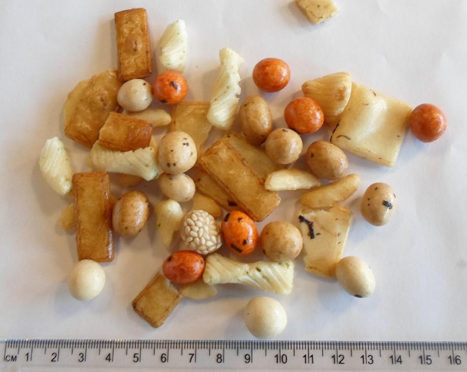 Varen er en blanding af rissnacks og indbagte jordnødder.
Varen kan indtages som føde/snacks uden yderligere tilberedning.
Varen er en blanding bestående af rissnacks og indbagte jordnødder med dej om-kring i forskellige former, udseende, farver og smage.
Ifølge ansøgningen indeholder varen 47,7% ris, 15,6 % jordnødder, 8,1 % sukker, 6,3 % majsstivelse, 2,7 % sojasauce, 2,0 % glukosesirup, 0,9 % maltodextrin, 0,7 % sesamfrø, 0,5 % salt og 0,3 % hævemiddel.
Varen er pakket i klar folie.