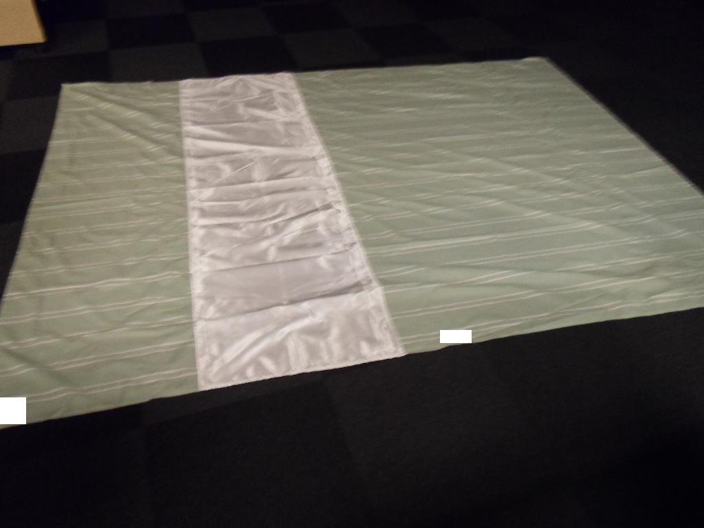 Varens samlede mål er W 2.800 x L 2.000 mm, hvoraf W 600 x L 2.000 mm udgøres af satin. Den resterende del af varen består af polycotton (bomuld og polyester). Tekstilstoffet af satin er skinnende og blankt, hvorimod tekstilstoffet af polycotton er mat og forsynet med tryk i form af striber.
Varen er et lagen af vævet tekstilstof syet i tre baner af hhv. satin og bomuld/polyester. En ikke-centreret del af lagenet del udgør et lavfriktionsområde. Varen er et fleksibelt tekstilprodukt, der fungerer som hjælpemiddel for selvhjulpne brugere i sengen.
Varen er fremstillet af to forskellige tekstiltyper bestående af hhv. bom-uld/polyester (polycotton) og polyester (satin).