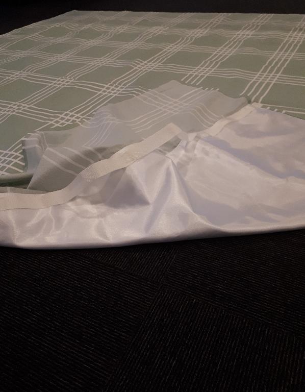 Varen måler W2.000 x L2.000 mm. Varens forside består udelukkende af polycotton, mens der på bagsiden er påsyet satin. Tekstilmaterialet af satin måler W1.470 x L2.000 mm og er placeret i midten på bagsiden. Dette tekstilmateriale er skinnende og blankt. Forsiden af polycotton er mat og forsynet med tryk i form af striber, som går både horisontalt og vertikalt. På bagsiden er der påsyet to hvide webbing bånd i lagenets fulde længde langs den hvide satin i hver side. Båndet er fastsyet i enderne og har en ikke gennemgående syning, men er fastsyet i sektioner med en afstand på 21-23,5 cm, som gør det muligt at anvende båndet som håndtag eller stropper i forbindelse med en løftestang.
Varen er et lagen til brug i sengen. Varen fungerer som et glidelagen med lavt friktionsmateriale af satin på bagsiden og kan glide i alle fire retninger. Dermed kan varen anvendes til forflytning op og ned i sengen og til flytning fra side til side. Desuden kan varen anvendes sammen med en løftestang ved at kombinere de påsyede håndtag hermed.
Varen er fremstillet af to forskellige tekstiltyper af henholdsvis satin (100 % polyester) og polycotton (55 % bomuld og 45 % polyester). Derudover er der påsyet to webbing bånd i lagenets fulde længde.