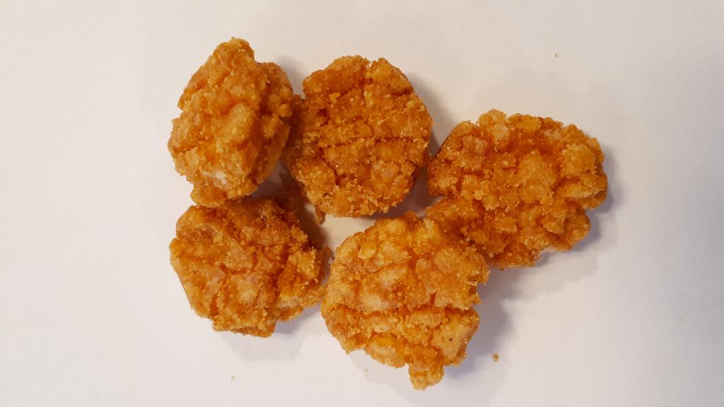 Varen foreligger som runde, orange stykker. De har en tykkelse på 0,5-1 cm og en diameter på 3 cm. Overfladen er ujævn og med revner i. Når varen knækkes, er den hvid inden i med små lufthuller. Krydderiet er således ikke æltet ind i varen under tilberedningen. Det ses tydeligt, at varen er lavet på basis af en dej.

Varen er sprød hele vejen igennem og smager af ris, chili og hvidløg. Varen dufter krydret af hvidløg og chili. Det kan duftes, at varen er tilberedt i olie.
Varen er en fødevare, der kan spises som snack.
Det er oplyst at varen indeholder følgende ingredienser: ris, vegetabilsk olie, sukker, stivelse, soja, krydderier.
Følgende næringsindhold er angivet: fedt, kulhydrater, heraf sukkerarter, protein og salt.
Varen foreligger i pakninger til detail og som bulkvare.