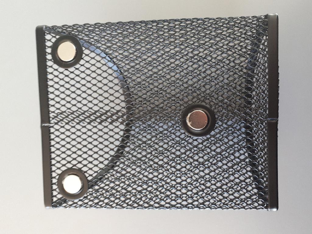 Varen fremstår som en trådkurv med tre magneter placeret på den ene side. Det er oplyst, at varen foreligger i to forskellige former, en med runde kanter og en med firkantede kanter.
Varen kan fx anvendes som holder til blyanter og lignende. Varen kan enten stå selv på en plan overflade, eller placeres på en plade, som tiltrækkes af magnetkraften i varen.
Det er oplyst, at varen er fremstillet af metal, mesh jern, med en belægning af polyestermaling.
Ifølge det oplyste, foreligger varen i følgende mål: 
10 cm bred, 12,5 cm høj og 5 cm dyb.
