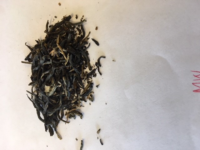 Varen foreligger som tørrede, rullede hele teblade med kuglelignende eller aflang form. Blandingen er mørk (brune og sorte nuancer) med enkelte lysere blade. Varen har en svag duft af halm/græs.
Varen anvendes til fremstilling af te.
Det er oplyst, at varen er fremstillet af ufermenteret hvid te. Teen er håndplukket i hele blade og efterfølgende rullet og soltørret.
Det er oplyst, at varen foreligger i løs vægt og indføres i mængder på 3 kg og der-under. Det er oplyst, at varen foreligger i en lufttæt beholder af pap indeholdende en pose af papir, hvori varen er placeret.