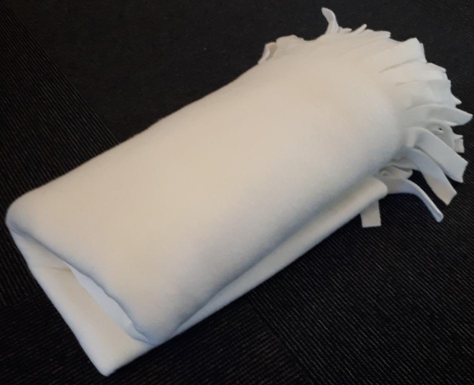 Varen er et fleecetæppe af trikotage med to opklippet kanter, der giver en effekt af frynser.
Varen har blandt andet funktion til at holde brugeren varm.
Varen er oplyst til at bestå af 100% polyester.
Varen kan foreligge i forskellige farver.