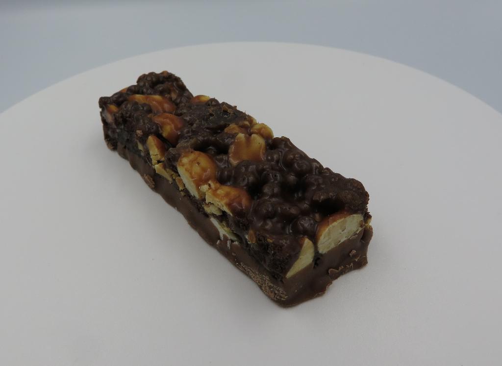 Varen fremstår som en aflang chokoladebar med indhold af peanuts, rosiner, chokoladestykker, sprøde ris og mælkechokolade. Smagen af peanuts og chokolade trænger mest igennem. Den har en bund af mælkechokolade, mens resten af ingredienserne er blandet på toppen.
Produktet anvendes til at indtage som snack.
Det er oplyst, at varen består af chokoladestykker, peanuts, rosiner, sprøde ris og mælkechokolade.
Baren forekommer i detailsalgsemballage, og har en oplyst vægt på 33 gram.