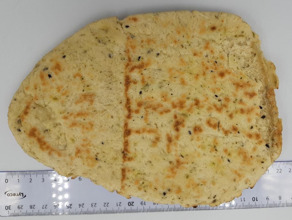Varen foreligger som flade, æggeformede, forbagte brød. 
Overfladen er gyldenbrun med synlige mørke nigellafrø og små stykker af finthakkede krydderier. Overfladen og kanten på brødet er ujævn.
Det er oplyst, at varen er en forbagt fødevare, der skal bages 3-4 minutter, inden den spises.
Varens ingredienser er hvedemel, vand, yoghurt, rapsolie, rehydreret hvidløg, sukker, salt, gær, nigella frø, hævemidler (E 450, E 500), hvedemel, sojamel, dextrose, konserveringsmiddel (E 282), koriander, surhedsregulerende middel (E 330), melbehandlingsmiddel (E 300).
Et brød måler ca. 21 x 15 cm og er ca. 1 cm tyk.
Varen er pakket med 2 stk brød i detailsalgsemballage med en oplyst nettovægt på 260 g.

Det er oplyst, at varens næringsindhold består af fedt, kulhydrater, heraf sukkerarter, kostfibre og protein.