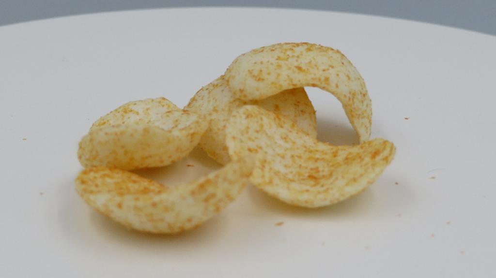 Varen foreligger som små buede, ovale, sprøde snacks, pakket i en cylinderformet metaldåse. 

Varen er hvid med orange prikker i overfladen, og den knaser. Smagen er mild, med en smag af gulerod, tomat og hvede.
Det er oplyst, at varen anvendes som snack til babyer fra 10 måneder og opefter.
Varen er oplyst til at bestå af hvedemel, havremel, solsikkeolie, tomat, rismel, gulerod, surhedsregulerende middel, løg, antioxidant og thiamin.

Næringstabellen angiver indhold af fedt, kulhydrater, heraf også sukkerarter, kostfibre, protein, salt og thiamin.
Varen foreligger i detailsalgsemballage med en angivet nettovægt på 35 g.