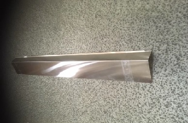 Varen er et emne af aluminium. Emnet er L-formet og har en overside og en forkant. Den nederste del af forkanten er ombukket og danner en bue, der er åben mod bagsiden. I den ene side af emnet er der klippet et hjørne af buen.
Det fremgår af det modtagne materiale, at varen er en tagfod og anvendes hvor tagpap- eller undertaget går over tagrenden. Det er oplyst, at varen er bukket konisk, så siderne kan gribe ind i hinanden.
Det er oplyst, at varen består af aluminium.
Følgende mål er oplyst:
Længde: 1 meter 
Oversiden: 100 mm dyb
Forkanten: 55 mm høj 
Tykkelse: 0,6 mm