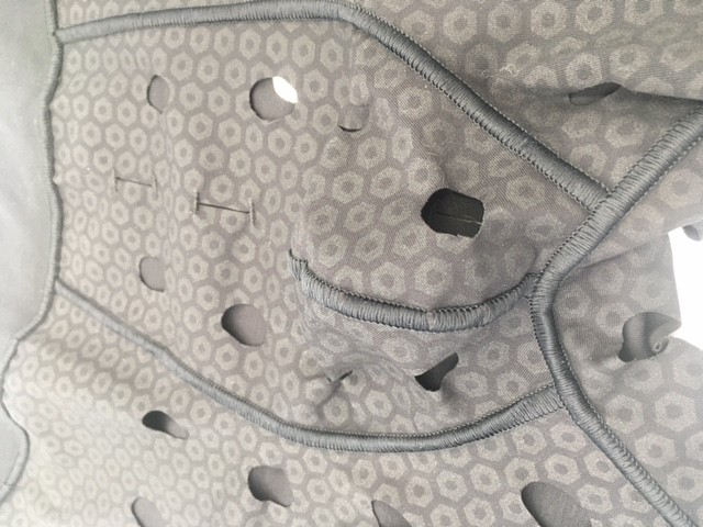 Varen foreligger som en elastisk beklædningsgenstand med korte ben. Varen er udformet som såkaldte boxer briefs. Varen er fremstillet af trikotagestof med gennemsigtigt gummiprint. Varen bæres på underkroppen.

Varens front har ingen gylp men er centralt forsynet med en såkaldt skamkapsel. Området ved skridtet og i lysken er forsynet med 22 runde huller. Centralt på fronten findes 2 lodrette sprækker afsluttet med knaphulssting øverst og nederst.

Varens bag er forsynet med 12 huller, og centralt på bagen findes 3 lodrette sprækker afsluttet med knaphulssting øverst og nederst.

Varens skridtstykke er forsynet med 6 huller.

Varens sømme er flade, strækbare overlock sømme. 

Varens linning er ca. 5 cm med isyet elastisk bånd. Varens ben er afsluttet med ombukket søm med dobbelt stikning. For en vare i størrelse L er benlængden ca. 10 cm. Sidelængden er 36 cm.
Det er oplyst, at varen er beregnet til fastholdelse af bandager ved balderne, i lysken og i skridtet.
Det er oplyst, at varen består af Micro Modal og elastan.
Ifølge oplysningerne foreligger varen i detailsalgsemballage. Varen findes i sort og foreligger i flere størrelser (S-2XL).