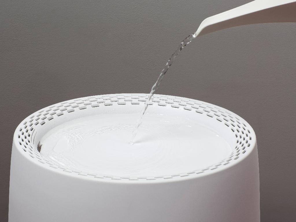 Varen er en luftfugter med mulighed for aromaterapi under anvendelsen.

Den har en afrundet bund, hvor der er påsat ben, således at bunden er hævet over underlaget. Toppen er udformet som en flad skål med mindre huller rundt langs toppen af hele kanten. Der er et større hul i siden af skålen, så vand der hældes i, ledes ind i varen.

Toppen kan tages af, således at varen deles i to dele.

På siden af den nederste del af varen er der en kontakt. Inde i den nederste del er der et vandfilter, samt en lille skål hvor aroma kan tilsættes.

Varen har en LED-indikator for vandpåfyldning og LED-stemningslys i bunden.
Varen er en selvregulerende luftfugter.

Det er oplyst, at vand hældes på toppen af enheden, som automatisk lukker når reservoiret er fyldt. Dette forhindrer, at vandet løber over. Ventilatoren i varen blæser derefter luft over det våde vandfilter, hvilket får vandet til at fordampe naturligt. Dette minimerer risikoen for overskydende befugtning. Der kan tilsættes lidt aroma for en behagelig duft.

Efter det oplyste er det muligt selv at vælge, hvor hurtigt man vil befugte luften. Der kan derfor vælges output på 100 eller 200 ml i timen. 

Vandfiltret er udskifteligt, og holder i op til 6 måneder.
Varen har efter det oplyste en indbygget DC-drevet (jævnstrøm) radialblæser til at lave luftstrøm og en ledning til strøm.
Det er oplyst, at varen er lavet i ABS plast, og at den har justerbar tågeudgangskontrol.
Der medfølger et standardvandfilter.
Varen foreligger i detailsalgsemballage. 

Varen måler 30 x 25 x 33 cm og vejer 2,8 kg

Varens størrelse gør den anvendelig til husholdningsbrug.