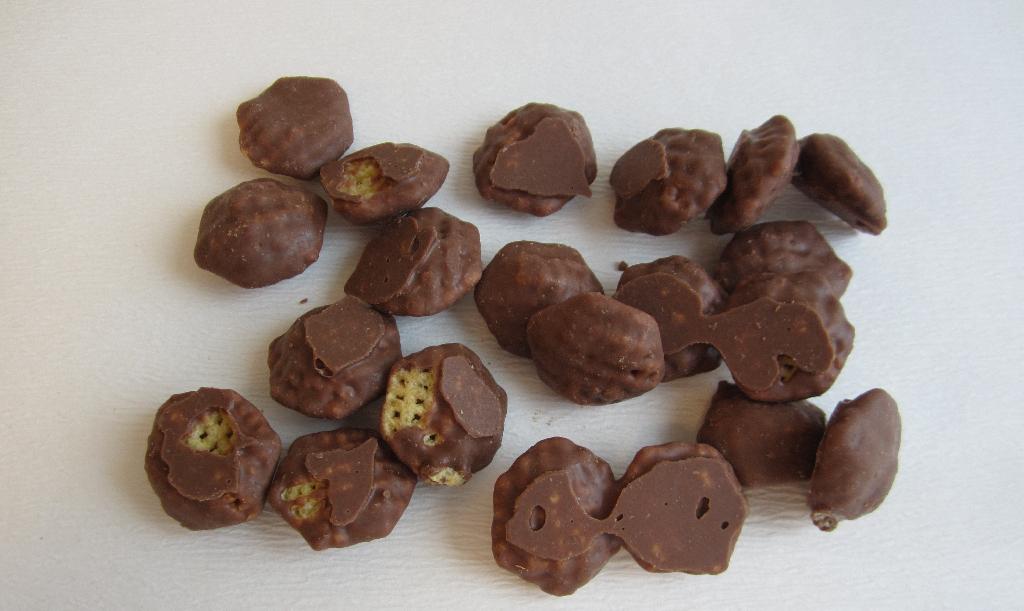Varen er ekstruderede majssnacks i form af små sekskanter, som er overtrukket med chokolade hele vejen rundt. Varen smager af saltede majschips med chokolade og er sprøde i smagen.
Varen er en fødevare og kan spises som en snack, klar til fortæring.
Varen består ifølge det oplyste af følgende ingredienser:
Sukker, kakaosmør, sødmælkspulver, majsmel, kakaomasse, hærdet raps- og kokosolie, hvedestivelse, salt, emulgator (E 322 soja) limepulver og aroma.
Varen måler cirka 2,5 x 2,5 cm med forskellig tykkelse. Posen indeholder 100 g.