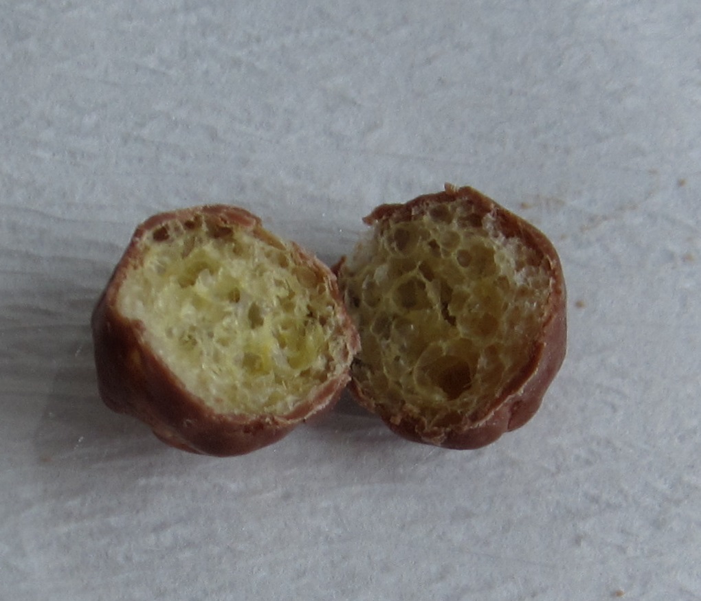 Varen er en tilberedt fødevare i form af ujævne, runde snacks. Udvendigt er varen helt dækket af et tyndt chokoladelag. Indvendigt består varen af en luftig og lidt sprød snackkugle. Varen smager af chokolade og lidt salt.
Varen er en fødevare klar til direkte fortæring og kan spises i en mundfuld.
Det er oplyst på varens emballage, at varen består af sukker, majsmel, kakaosmør, sødmælkspulver, kakaomasse, salt, overfladebehandlingsmiddel, syre, emulgator, glukosesirup, aroma, raps- og kokosolie.
Varen foreligger i poser indeholdende 180 g.