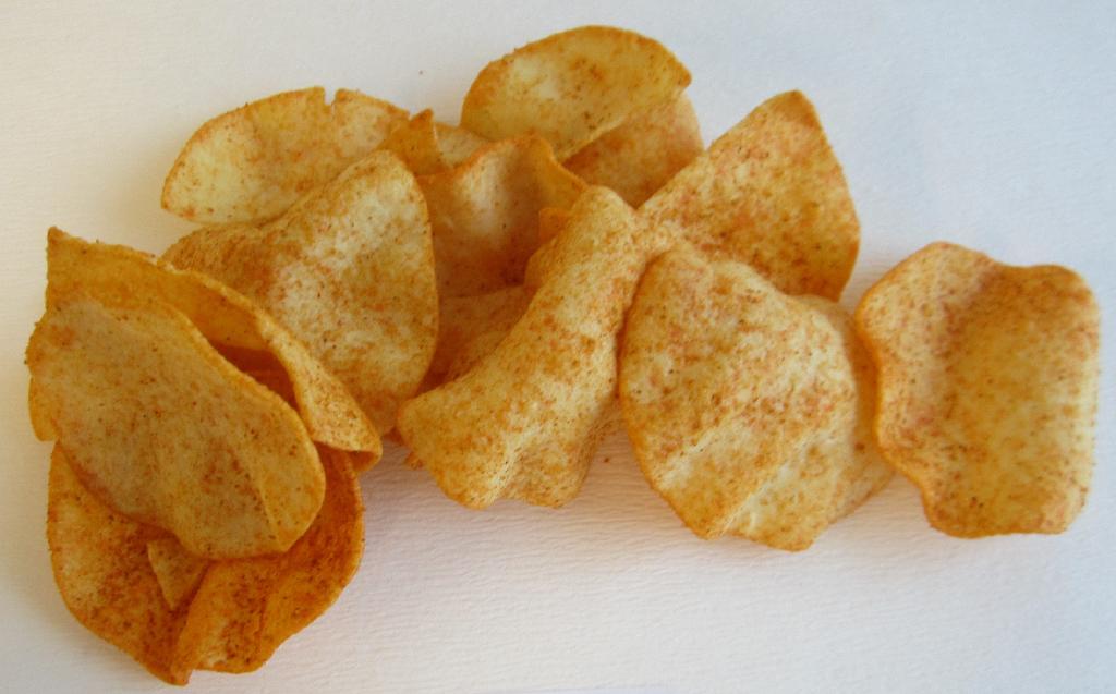 Varen er lysegule chips med en rund, ujævn form. På overfladen ses et rødt og orange pulver. Varen har en tør og sprød konsistens. 
Varen dufter lidt sødt og krydret og smager let salt og af paprika.
Varen er en fødevare.
Det er oplyst, at varen består af kartoffelpulver, kartoffelstivelse, vegetabilske olier, paprika, salt, dextrose, løgpulver, naturlig paprikaaroma, hvidløg, chili- og paprika-ekstrakt, sort peber, rosmarinekstrakt, farvestof, chili. 
Det er oplyst, at varen er lavet af en dej, der er ekstruderet, tørret og friteret.
Den fremsendte vareprøve er pakket i uigennemsigtig detailsalgsemballage indeholdende 140 gram.