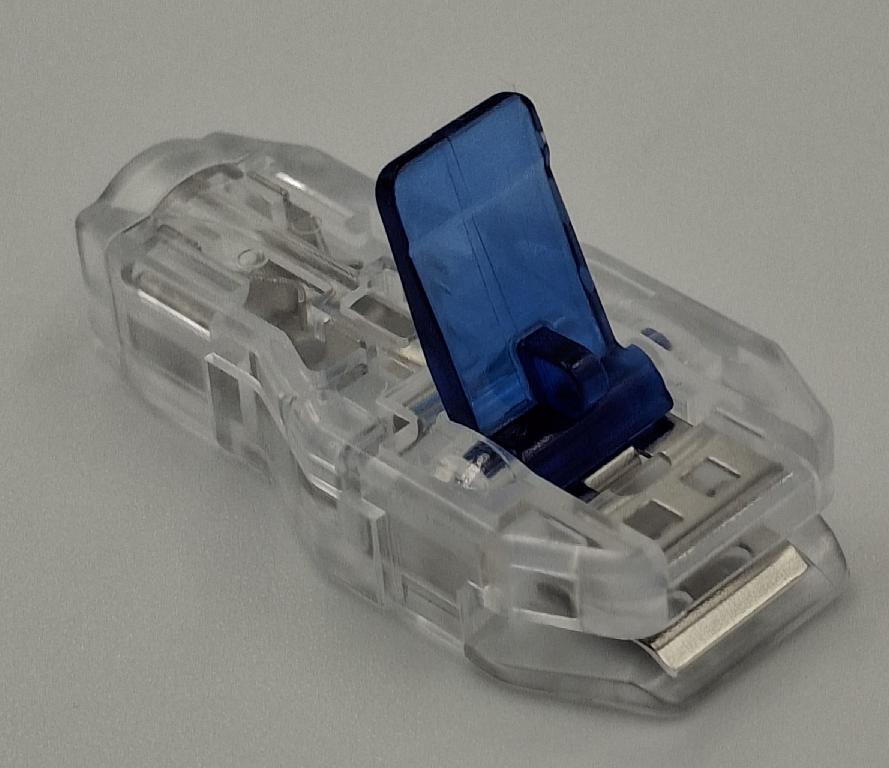Varen er en forbindelsesdel til et elektrisk kredsløb i form af en flad, aflang plastanordning, med en metalindsats i hele varens længde. I varens ene ende er der en indgang (hunstik) til et 3-4 mm bananstik, mens der i den anden ende er en klemmean-ordning. Under bunden er der i klemme-enden et hul.
Det er oplyst, at varen kan skabe forbindelse mellem en EKG-elektrode og en ledning.
Klemmeanordningen gør det muligt at klemme varen fast om en flad elektrode eller at fastgøre varen til en knop-formet elektrode ved hjælp af hullet under bunden.
Varen består af plast og metal.
Varen er pakket i detailsalgsemballage indeholdende 10 stk.
Varen er ca. 3,5 cm lang, 1,5 cm bred og 0,7 cm høj.