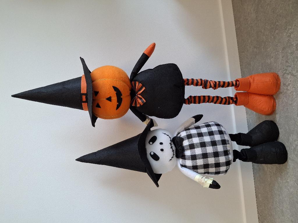 Varen er en halloweenfigur af tekstil med støvler, tynde tekstilbeklædte teleskopben, der kan ændre længde, en afrundet krop, et hoved, lange arme og en høj, spids hat. 

Varen findes i to varianter: 
- en sort/hvid udgave med et hvidt hoved med et kranie-agtigt udtryk med aflange øjne, runde næsebor og en lang, sammensyet mund. Kroppen er sort/hvid ternet og den har sort butterfly. Hatten, benene og støvlerne er sorte og armene er hvide med sorte hænder. 
- en sort/orange udgave med et orange, græskarformet hoved med trekantede øjne og næse og en halvåben mund med nogle få tænder. Den har en sort hat beklædt med orange bånd, hvorpå der er en sort firkant, der er åben i midten, så det ligner et spænde. Kroppen er sort med en orange/sort stribet butterfly, og armene er sorte med orange hænder Den har orange/sort stribede ben og orange støvler.
Varen er til dekoration ved højtiden halloween.
Ifølge det oplyste er varen fremstillet af filt, vævet tekstil og fleece og fyldt med vat, støvlerne har træ i bunden og benenes teleskopfunktion er af stål.
Varen måler mellem 70 og 100 cm alt efter benenes indstilling.