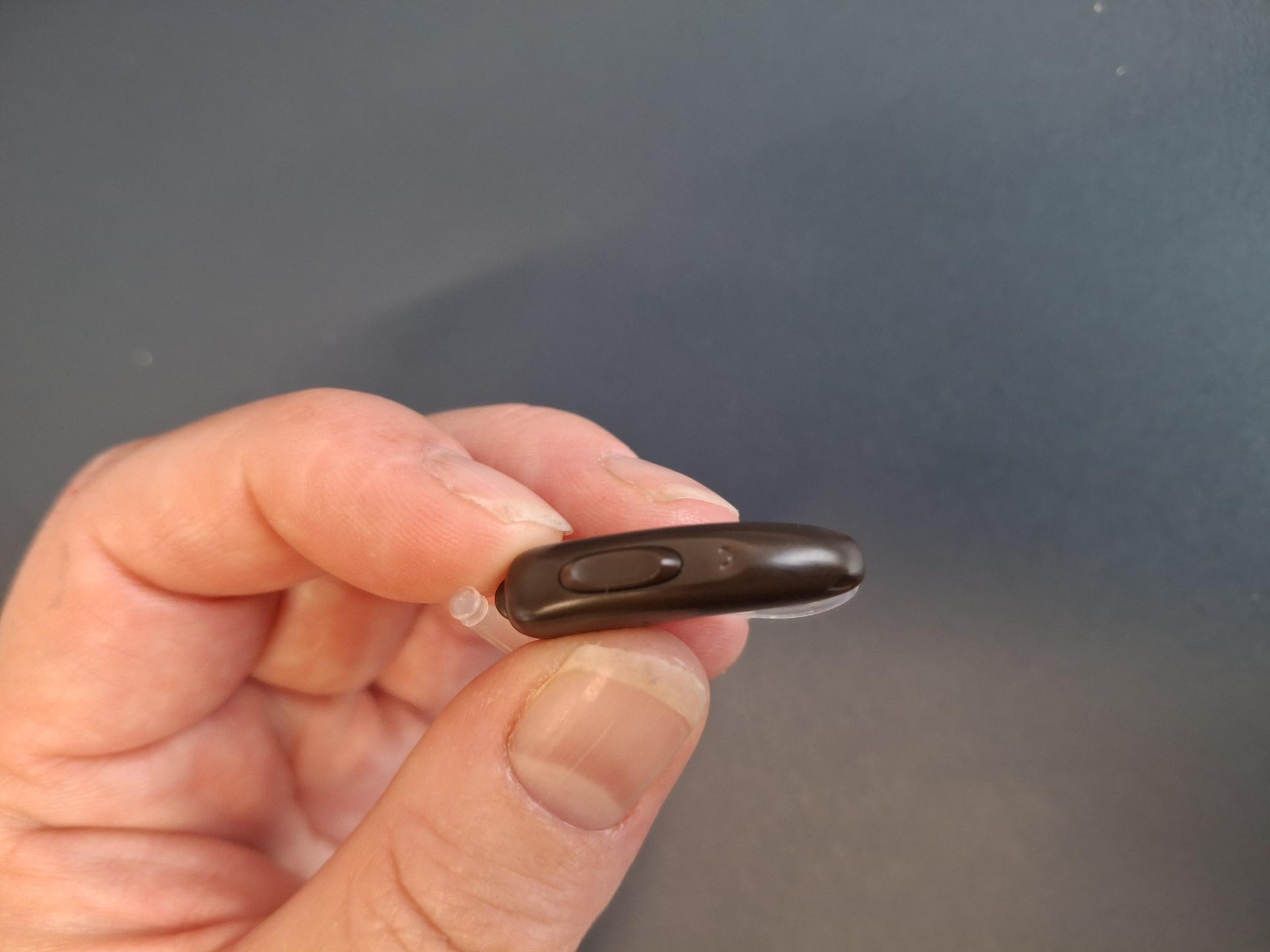 Varen er en dummy-udgave af et høreapparat. Varen er dråbeformet med en fleksibel plasttråd. For enden af plasttråden er der en lille spids, der er formet som en plastcylinder. På siden af den del, som er formet som en dråbe, sidder en knap. Knappen kan ikke trykkes ind og virker ikke. Inde i varen er en magnet.
Det er oplyst, at varen er en dummy-udgave af et høreapparat, der skal anvendes til demonstrationsbrug i forbindelse med afprøvning af, hvilken model og størrelse slutbrugeren skal have i høreapparat. Varen findes i forskellige størrelser, da modellerne skal kunne tilpasses forskellige størrelser af ører. 

Det er oplyst, at varen ikke har de aktive funktioner som et høreapparat normalt indeholder, og derfor ikke er brugbar som høreapparat. 

Ifølge det oplyste, er der en magnet i varen, så varen kan sidde på displays og holdere til fremvisning.
Det er oplyst, at varen er lavet af plast, og at varen ikke indeholder elektronik. Inde i varen sidder en magnet.
Det er oplyst, at varen kan fås i forskellige modeller/størrelser, modeller og farver. Varen kan fås enkeltvis eller som sæt.