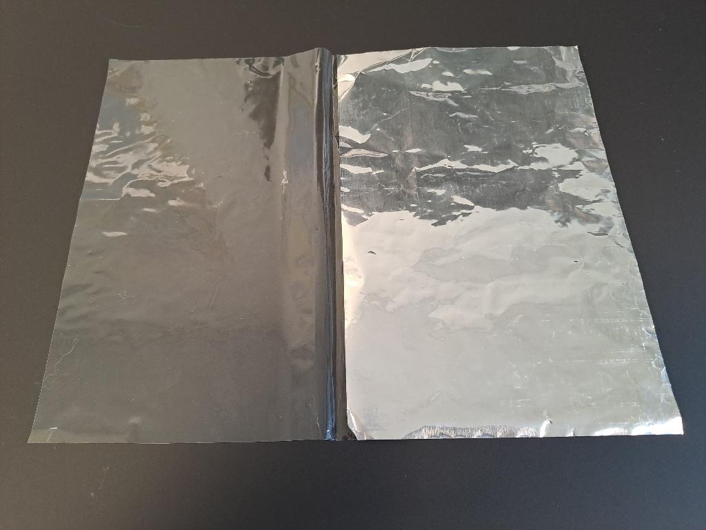 Der er tale om et såkaldt pålægsark. Arket består af et rektangulært stykke film af plast, hvor der er lamineret et stykke aluminium ovenpå den ene halve side af filmen. Det overskydende stykke plastfilm er foldet ind over aluminiumsstykket så det danner et ark.
Pålægsarket er beregnet til at transportere og opbevare skåret pålæg. Pålægget lægges på siden med aluminiumstykket og over pålægget foldes det overskydende stykke folie, som er med til at beskytte pålægget.
Varen består af plast af polypropylen og aluminium.
Arket måler 19 cm * 24 cm udfoldet og aluminiumstykket måler 9,5 cm * 24 cm.