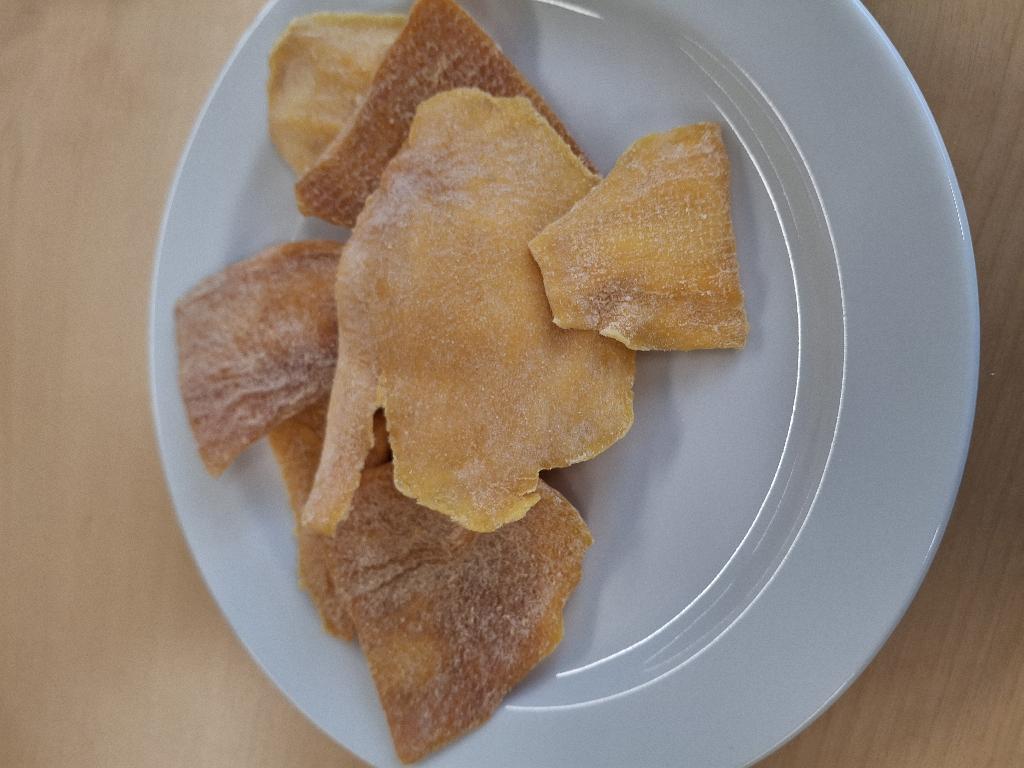 Varen er flade, uensartede stykker af tørret mango. Mangostykkerne er orange og har en ru overflade med hvidt pulver. Varen dufter sødt af mango og smager sødt og syrligt af mango og har en mild citronsmag.
Varen er en fødevare, der kan spises som den er.
Varen er tørret mango med citronsmag og består af mango, sukker, citronpulver, surhedsregulerende middel (citronsyre), naturlige citronaroma og konserveringsmiddel (natriumdisulfit).
Varen foreligger i detailsalgspakninger med en nettovægt på 100 g.
