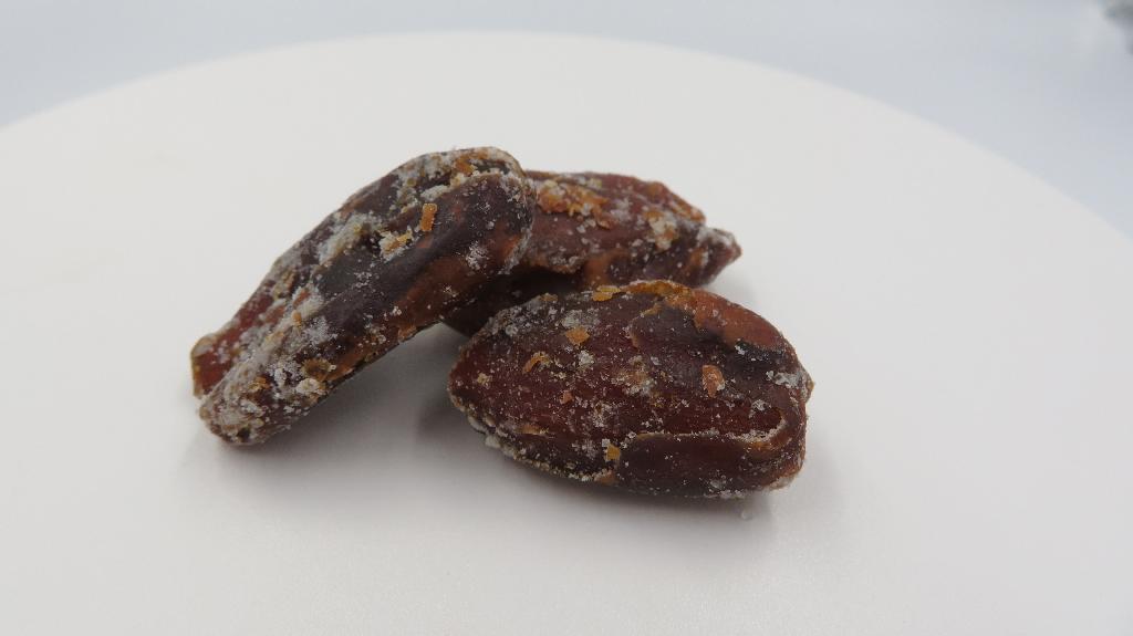 Varen består af tørrede dadler med et hvidt krystallinsk pulver på. Dadlerne er lidt seje i konsistensen og lidt bløde indeni.
De dufter surt og har en smag af sur cola.
Varen kan indtages direkte som en snack.
Ifølge det oplyste indeholder varen udstenede dadler, aroma, surhedsregulerende middel og kokosolie.
Den modtagne vareprøve foreligger i detailsalgsemballage indeholdende 100 g nettovægt.