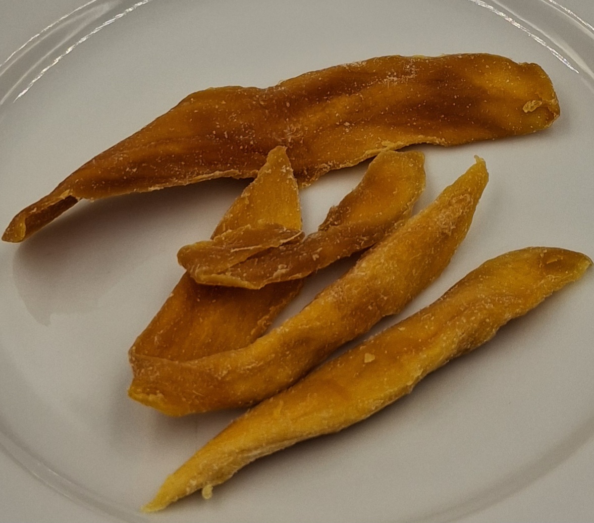 Varen er tynde, uensartede og tørrede mangostykker, der er orange/gule med hvidt pulver på. Varen dufter sødt og har en sød smag af mango.
Varen er en fødevare, som kan spises uden yderligere tilberedning.
Det er oplyst, at varen er mango med sukker, surhedsregulerende middel og konserveringsmiddel.
Varen er pakket i detailsalgsemballage med ståbund. Oplyst nettovægt: 60g.